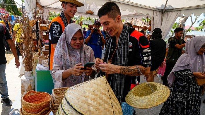 Maverick Vinales saat beli topi bambu di Lombok. Maverick Vinales, pembalap asal Spanyol kembali mencuri perhatian ketika mengikuti tren di medsos Indonesia: Cukurukuk hingga pinjam dulu seratus.