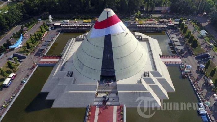 Tim pemanjat tebing Mapala UPN Veteran Yogyakarta membentangkan bendera raksasa di puncak bangunan Monumen Yogya Kembali, Sleman, Jogja