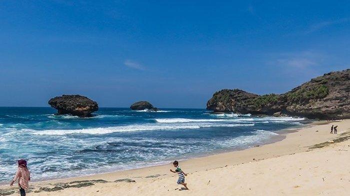 WISATA PACITAN - Potret keindahan yang ditawarkan Pantai Srau dengan hamparan pasir putih dan air lautnya yang biru, Senin (2/6/2025).