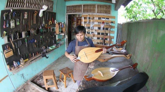 Pengrajin alat musik gambus Melayu, Robithah Irawan (34) tengah bekerja di workshop nya Jalan Kartama Pekanbaru, Jumat (9/8/2024).