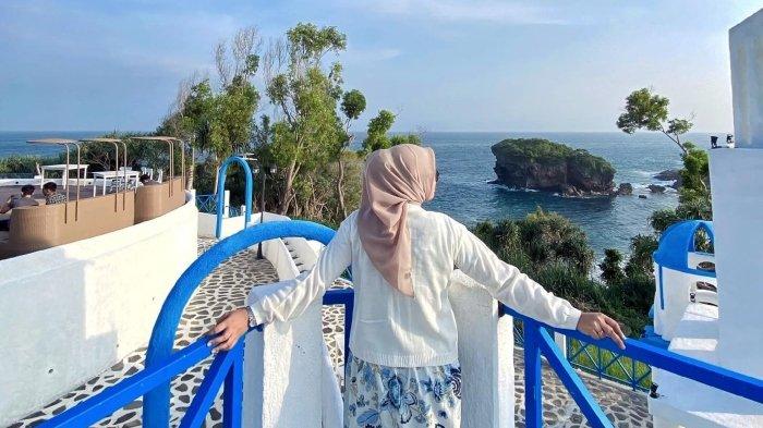 Pengunjung berfoto di Jungwok Blue Ocean berlatar pesisir pantai selatan Gunungkidul, Jogja.
