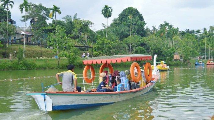 Pengunjung bermain wahana perahu air di Kampoeng Radja, tempat wisata ramah keluarga di Kecamatan Kota Baru, Kota Jambi, Jambi.