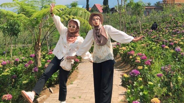 Pengunjung berpose di Wisata Dusun Kuliner Kota Batu, Jawa Timur.
