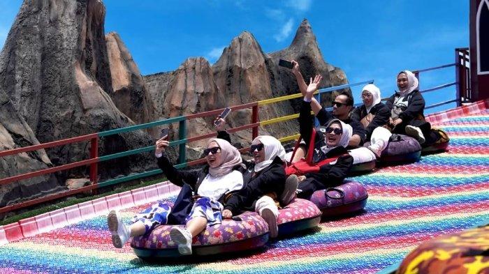 Pengunjung naik wahana rainbow slide di Florawisata Santerra Malang, Jawa Timur.
