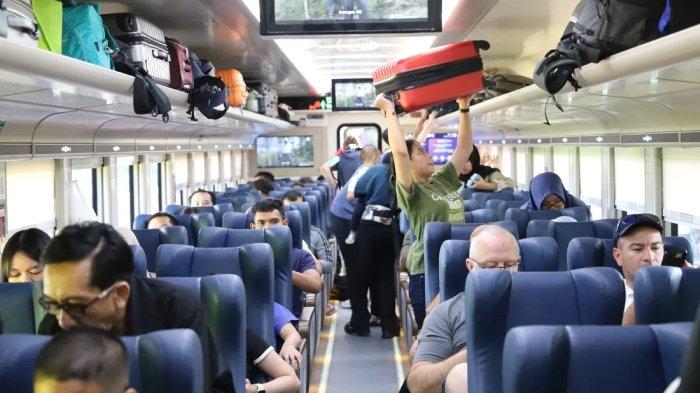 Penumpang kereta api memasuki gerbong kereta. 