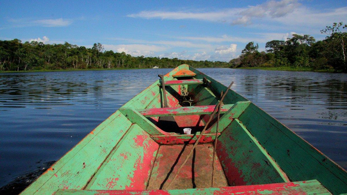 Perahu dayung kayu tua yang melintasi Sungai Amazon.