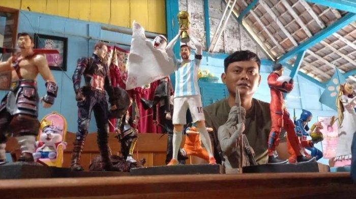 Derry Guda Dharma, perajin patung action figure menunjukkan karyanya yang dibuat dari bahan plastisin atau malam saat ditemui di rumahnya.