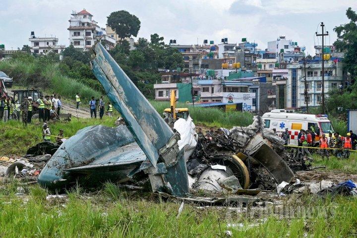 Petugas keamanan memeriksa sisa-sisa pesawat Saurya Airlines setelah jatuh saat lepas landas di Bandara Internasional Tribhuvan di Kathmandu pada 24 Juli 2024. - Sebuah pesawat penumpang jatuh saat lepas landas di Kathmandu pada 24 Juli, dengan pilot diselamatkan dari reruntuhan pesawat yang terbakar tetapi seluruh 18 orang lainnya tewas, kata polisi di ibu kota Nepal kepada AFP.