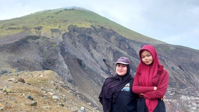 WISATA - Potret Putri (kiri) dan Elsa (kanan), saat mengabadikan momen akhir pekan di Kawah Tompaluan Gunung Lokon, Minggu (1/6/2025).
