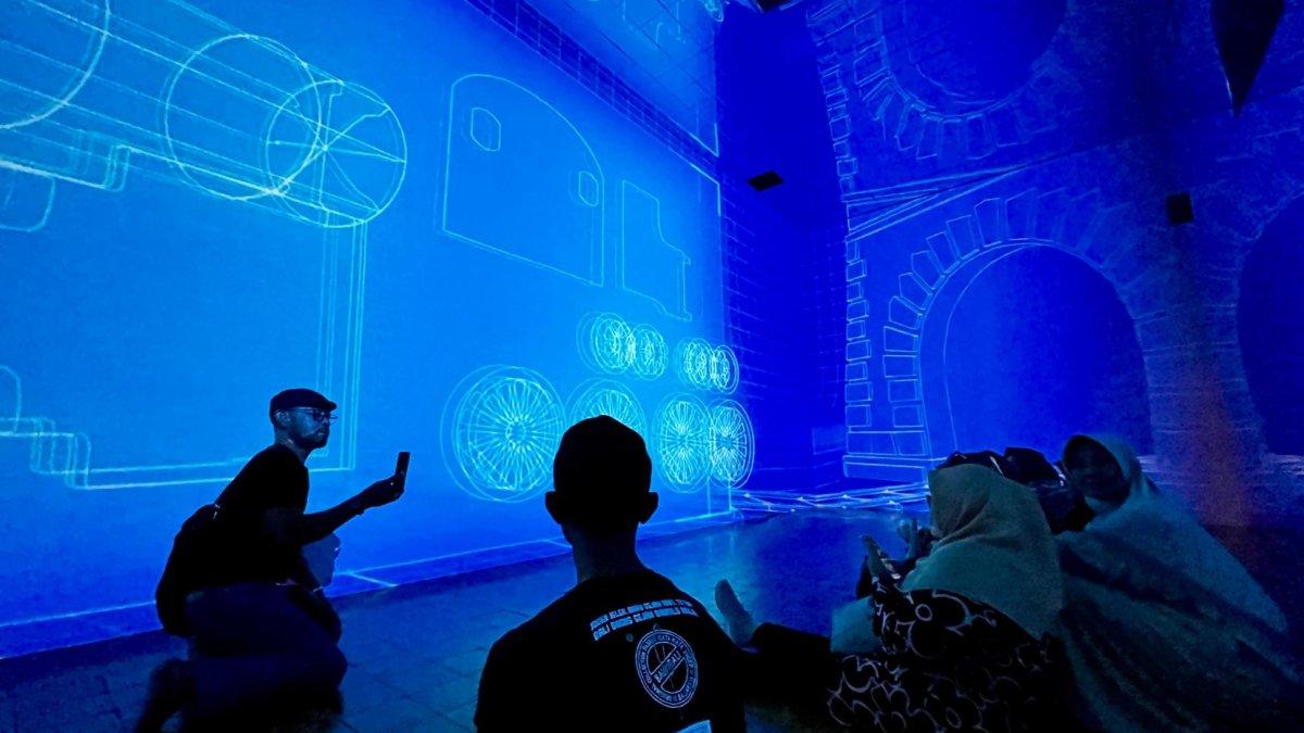 RUANG IMMERSIVE - Sejumlah pengunjung berfoto di ruang immersive Lawang Sewu, Jumat (20/6/2025). Ruang immersive menampilkan sejarah perkeretaapian Indonesia secara digital menggunakan teknologi proyeksi 3D mapping, animasi, dan suara surround.