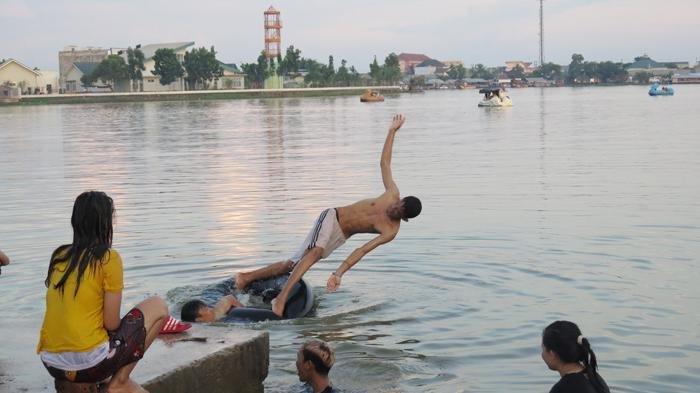 Sejumlah warga mandi di Danau OPI, Jakabaring, Palembang.