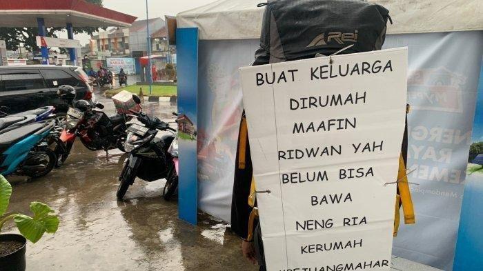 Seorang pemudik membawa tas memasang tulisan menyentuh permohonan maaf untuk kedua orangtuanya karena belum bisa membawa jodohnya, Selasa (9/10/2024).