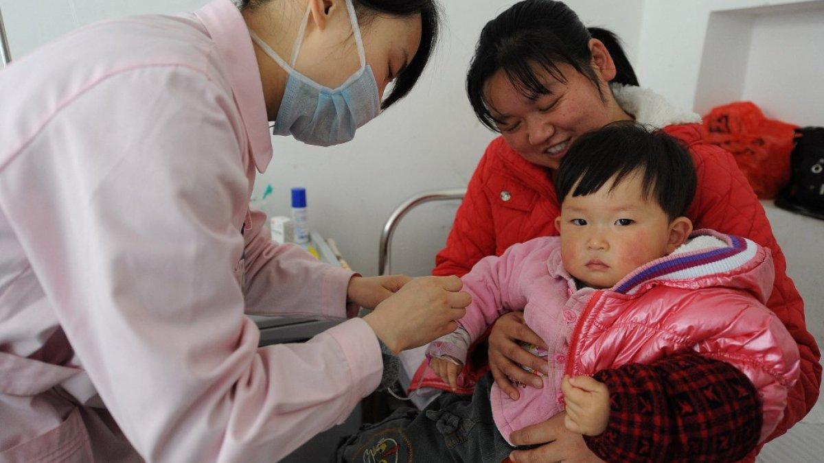 Seorang perawat Tiongkok merawat seorang anak yang sakit dalam pelukan ibunya di sebuah rumah sakit di Hefei, provinsi Anhui, Tiongkok tengah pada tanggal 29 Juni 2010. Pneumonia masih menjadi penyebab utama kematian di antara anak-anak Tiongkok, menurut sebuah studi baru tetapi jumlahnya jumlah anak-anak di Tiongkok yang meninggal sebelum mencapai usia lima tahun telah menurun sebesar 70 persen sejak tahun 1990, terutama karena perawatan medis yang lebih baik.