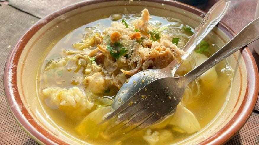 Seporsi Soto Lamongan Pak Tri yang dilengkapi dengan suwiran ayam, irisan telur, dan bubuk koya, Senin (29/7/2024).