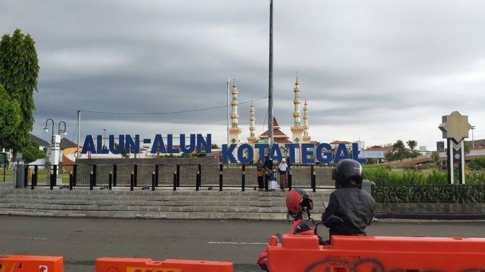 Warga sedang berfoto di pagar depan ikon bertuliskan Alun-alun Kota Tegal, Jawa Tengah.