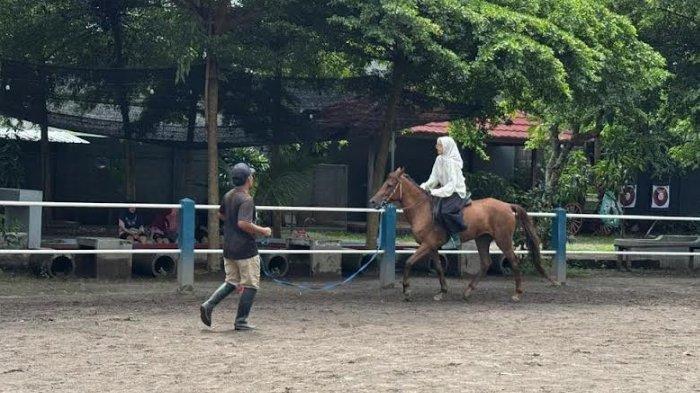 Umar Abu Faruq memandu dan mendampingi pengunjung yang sedang berkuda di Wisata Berkuda Sumber Tawang Stable Horse Riding, Pare, Kediri, Rabu (29/1/2025).