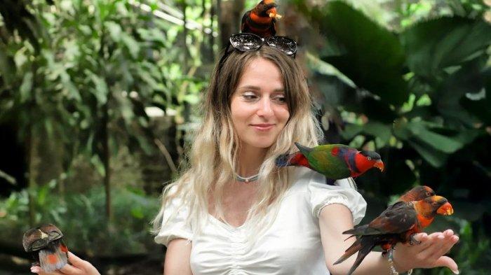 Wisatawan berfoto dengan burung di Bali Bird Park, tempat wisata ramah keluarga di Kecamatan Sukawati, Kabupaten Gianyar, Bali.