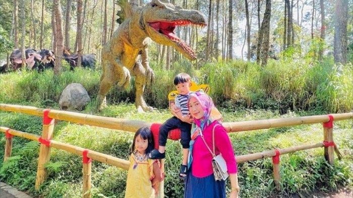 Wisatawan berfoto dengan replika dinosaurus di Mojosemi Forest Park Magetan, Jawa Timur.