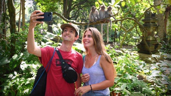 Wisatawan foto selfie dengan monyet di Monkey Forest Ubud Bali.