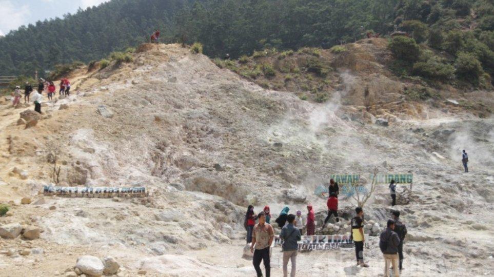Wisatawan mengunjungi Kawah Sikidang di Kawasan Wisata Dieng di Kabupaten Banjarnegara, Minggu (5/8/2017). Kawah yang masih menunjukkan aktivitas vulkanik menjadi daya tarik pengunjung.