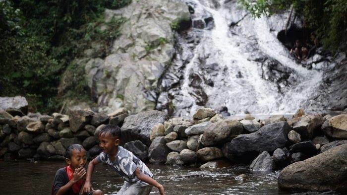 Wisatawan sedang bermain air di kolam wisata Air Terjun Wadung Kecemplung, Kecamatan Batealit, Kabupaten Jepara.