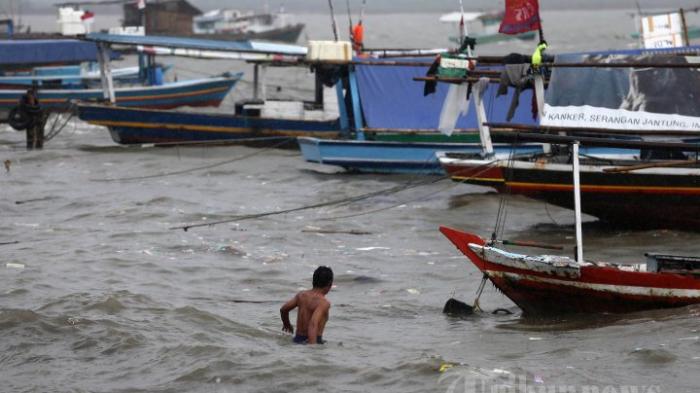Nelayan menuju perahunya di Pelabuhan Tanjung Pasir, Teluk Naga, Tangerang, Banten, Selasa (17/2/2015). Angin kencang dan tingginya ombak dikeluhkan para nelayan kecil di kawasan tersebut, karena menyulitkan mereka untuk mendapatkan ikan dan rajungan.