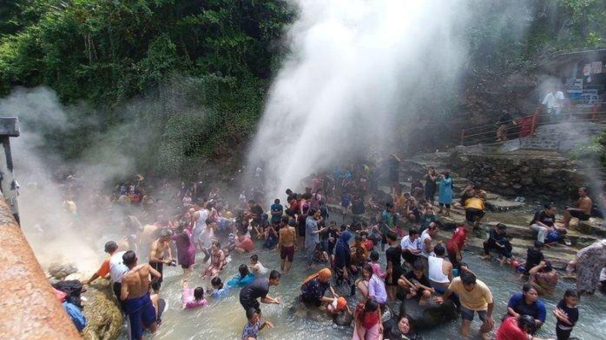 Wisatawan saat mandi di sumber air panas di Geyser Cisolok, Kabupaten Sukabumi, Minggu (30/4/2023).