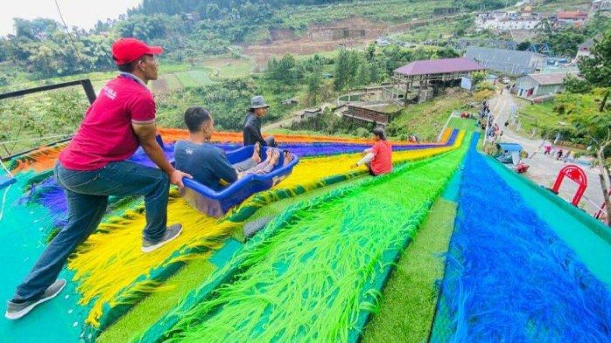 Wisatawan menjajal wahana perosotan pelangi yang memiliki panjang sampai 74 meter dan tinggi 12 meter di Golden Park, sabtu (8/10/2022).