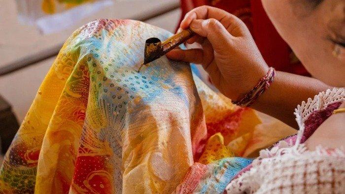 Ilustrasi proses pengerjaan batik menggunakan canting.