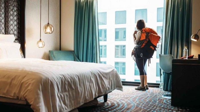 Ilustrasi wanita di kamar hotel saat liburan.
