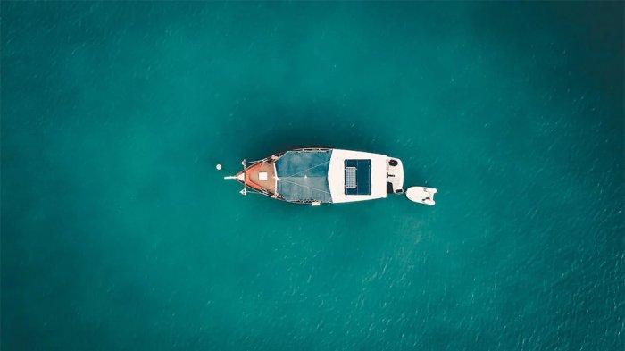Ilustrasi perahu di tengah laut.