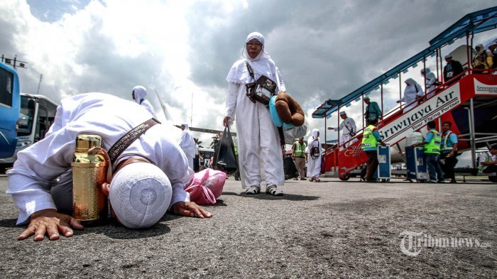 Seorang jemaah haji sujud syukur saat tiba di Bandara Depati Amir, Pangkalan Baru, Kepulauan Bangka Belitung, Sabtu (24/9/2016).