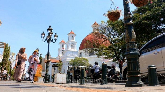Wisatawan terlihat memenuhi kawasan Kota Lama untuk sekedar jalan- jalan dan berswa foto berlatar bangunan berarsitektur kuno khas negeri kincir angin, Sabtu (25/07/20).