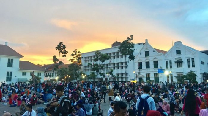 Wisata Kota Tua dipadati pengunjung, tepatnya duduk lesehan di pelataran Museum Fatahillah saat malam tahun baru 2018, Jakarta, Minggu (31/12/2017).