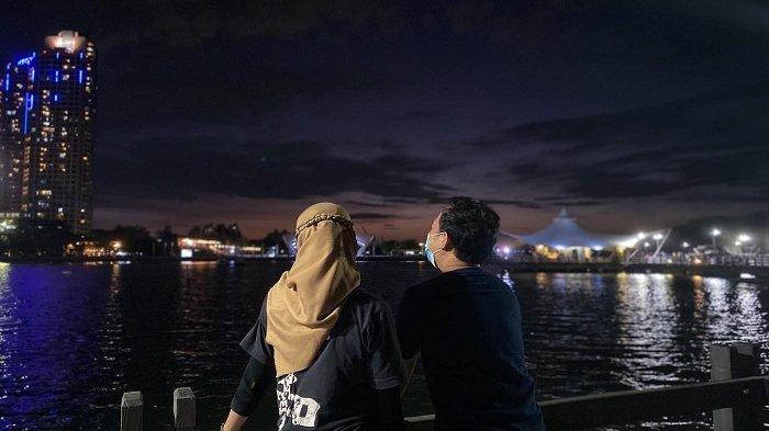 Ilustrasi wisatawan liburan ke Ancol saat malam hari.