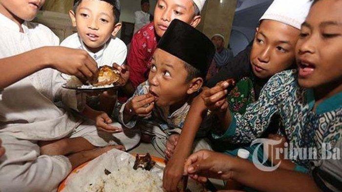 Sejumlah anak-anak menyantap hidangan berbuka puasa dalam tradisi megibung saat bulan Ramadan di Masjid Al-Muhajirin, Kampung Islam Kepaon, Denpasar.