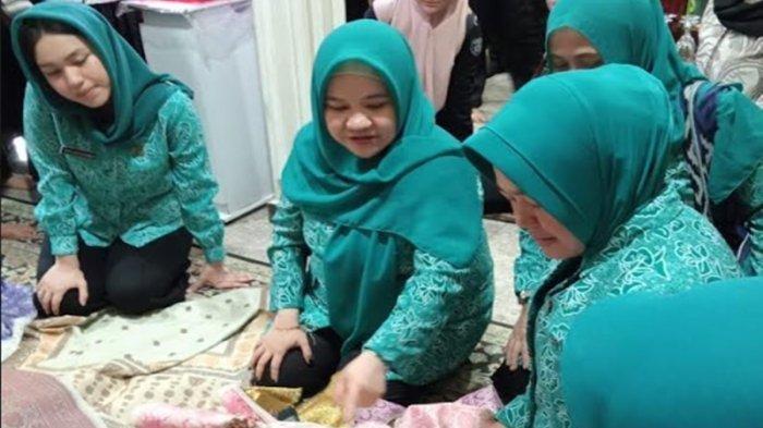 Pj Ketua TP PKK Provinsi Sumatera Selatan Melza Ayu Rahminia (tengah), didampingi Ketua TP PKK Kabupaten Ogan Ilir Mikhailia Tikha Alamsjah (kiri) saat memilih songket pewarna alam hasil produksi Elita Songket pada Selasa (30/7/2024) lalu.