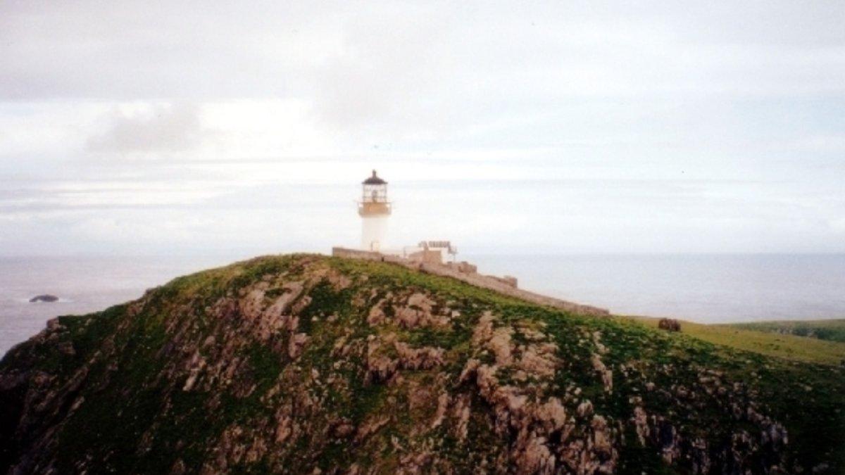 Mercusuar di Eilean Mor di Kepulauan Flannan. Hilangnya tiga penjaga cahaya secara misterius pada bulan Desember 1900. Kapel St Flann dapat dilihat di lereng bawah (ke kanan) mercusuar.