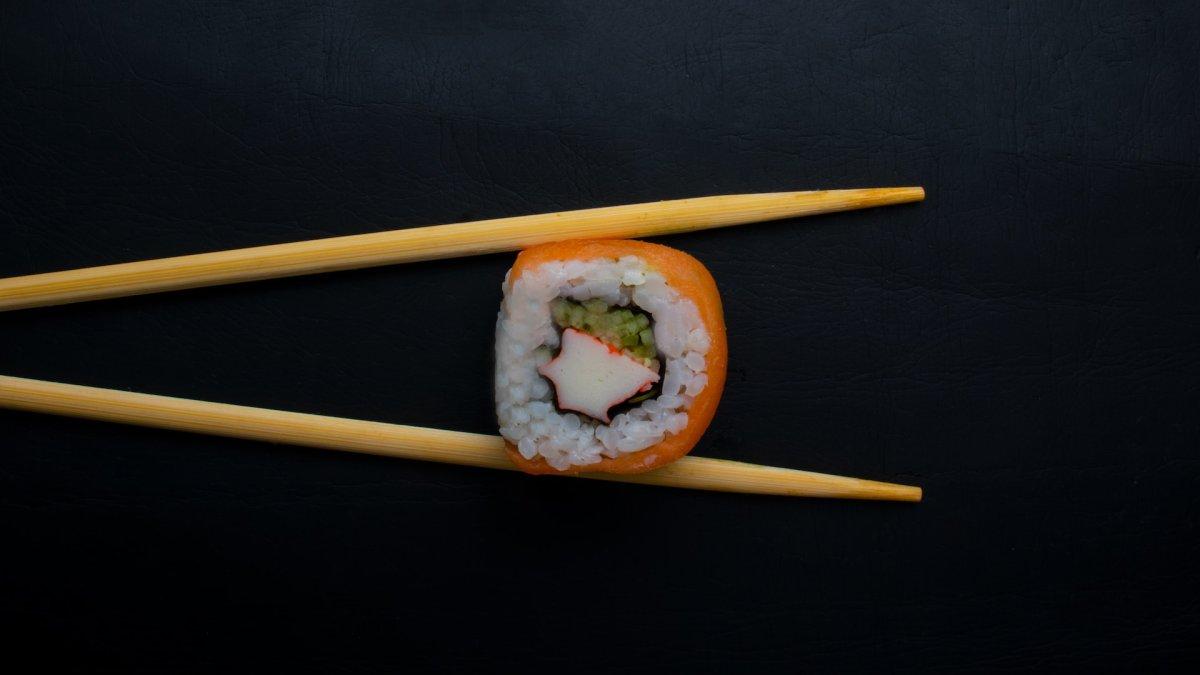 Ilustrasi makan sushi pakai sumpit