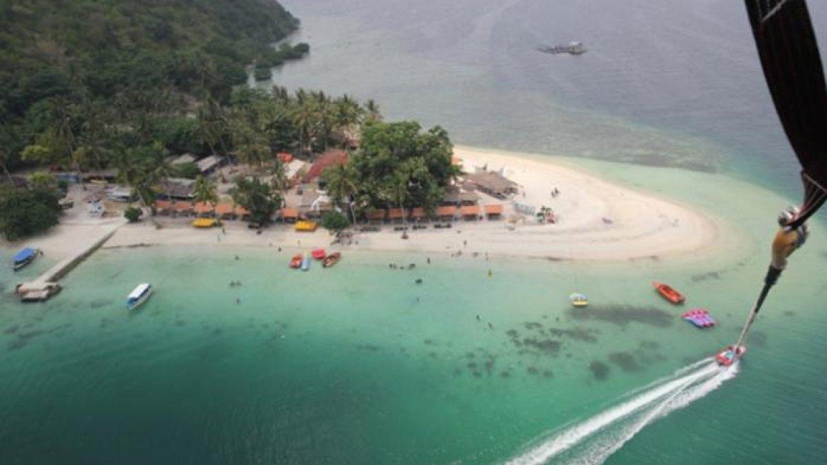 Keindahan Pulau Tangkil, Pantai Mutun di Pesawaran, Lampung yang terekam dari udara menggunakan parasailing. Lokasinya dekat dengan penginapan dan tempat sewa motor.
