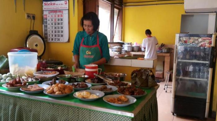 Ibu Yayuk, seorang pegawai Depot Nasi Pecel 99 milik Karyono di Jalan Cokroaminoto No 99, Kota Madiun, Jawa Timur, sedang melayani pelanggannya.