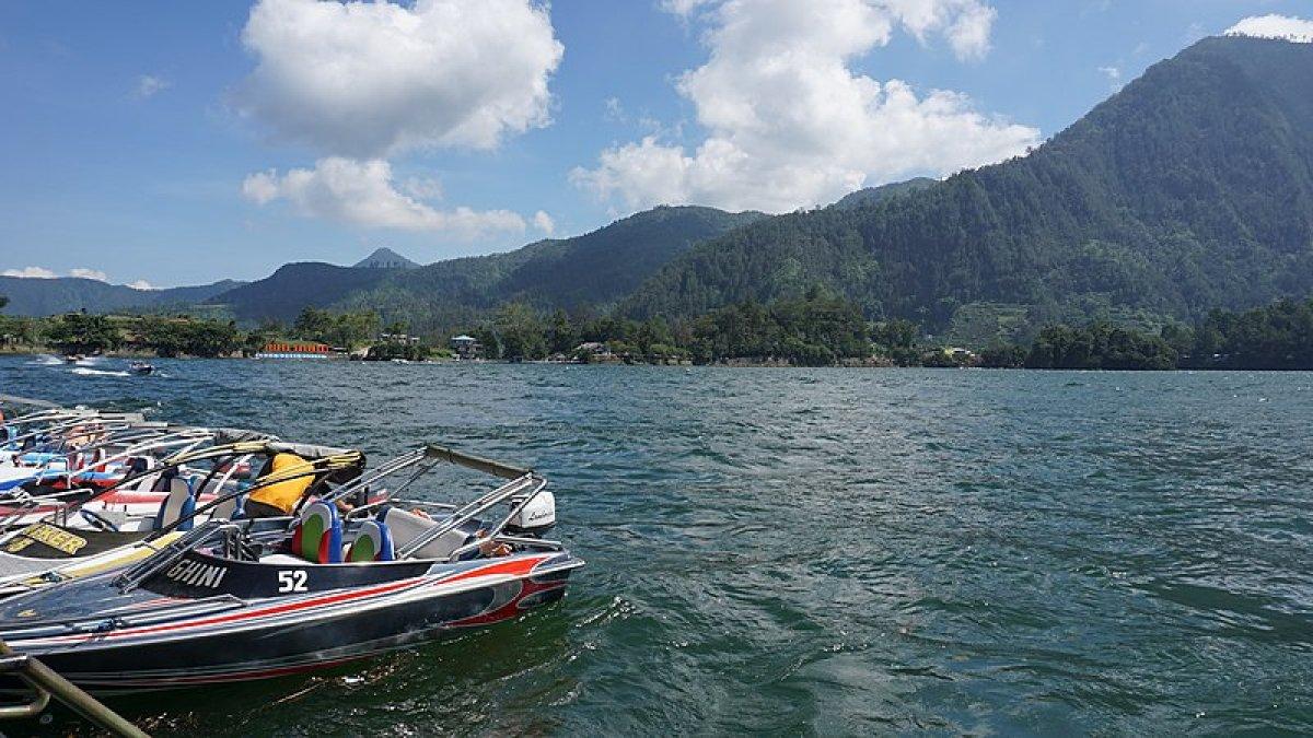 Pemandangan ke Telaga Sarangan Magetan dengan perahu motor di dermaga.