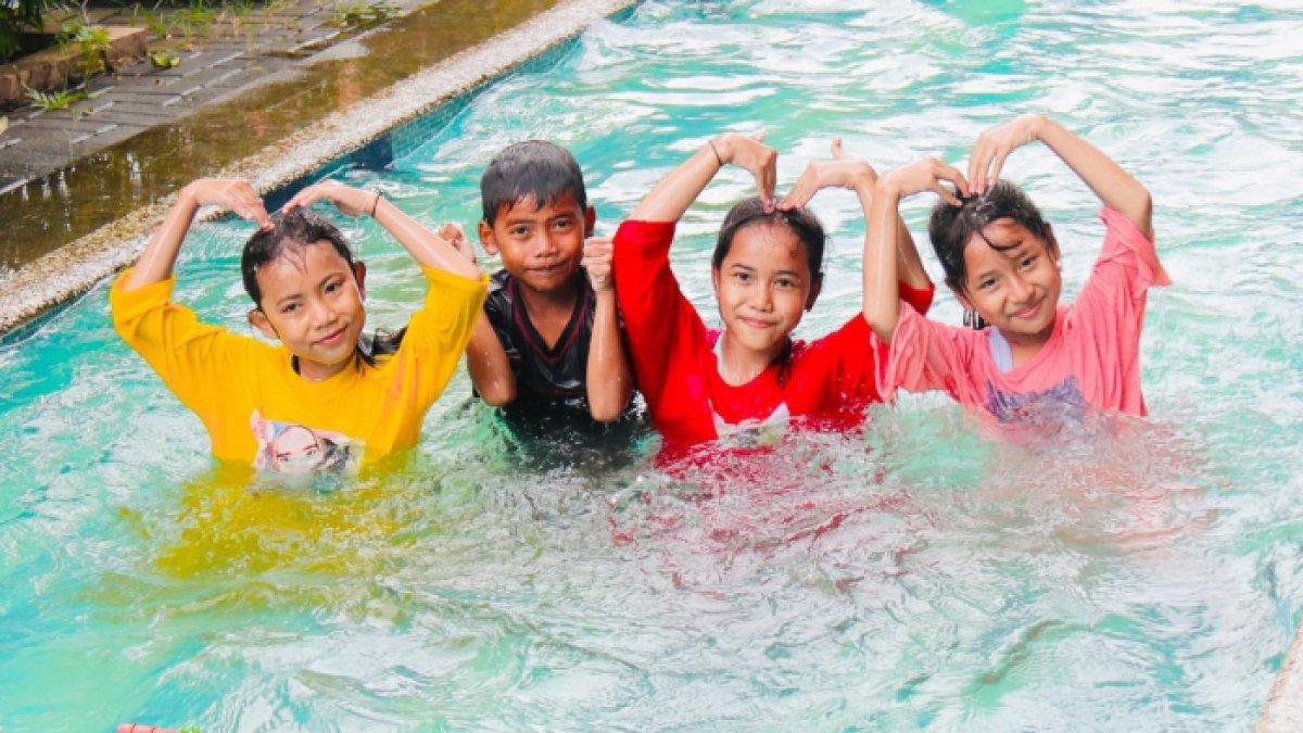 Pengunjung berfoto di kolam renang Boash Waterpark, tempat wisata Bogor yang lokasinya dekat hotel dan tempat sewa mobil.