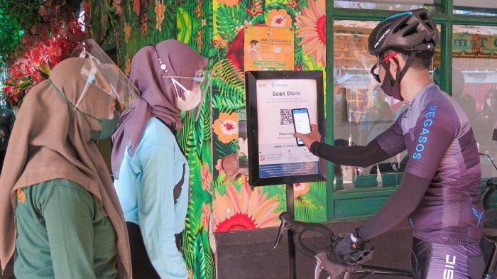 Pengunjung yang sedang scan Aplikasi PeduliLindungi sebelum masuk ke Kebun Binatang Surabaya.