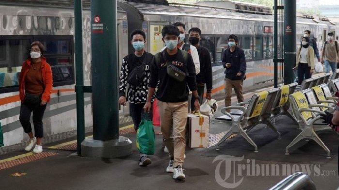 Penumpang kereta api Argo Lawu berjalan saat tiba di Stasiun Gambir, Jakarta Pusat.
