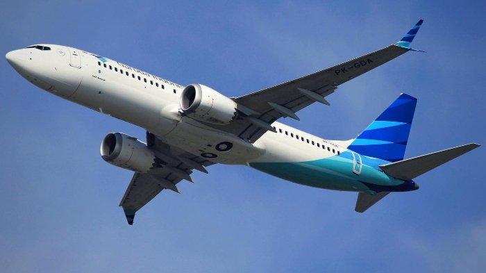 Pesawat Garuda Indonesia yang sedang mengudara, tampak dari samping
