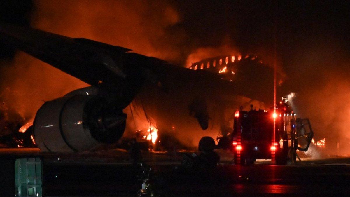 Sebuah mobil pemadam kebakaran terlihat di samping pesawat penumpang Japan Airlines (JAL) di landasan Bandara Internasional Tokyo di Haneda pada 2 Januari 2024. Sebuah pesawat Japan Airlines terbakar di landasan Bandara Haneda Tokyo pada 2 Januari setelah tampaknya bertabrakan dengan sebuah pesawat penjaga pantai, kata laporan televisi.