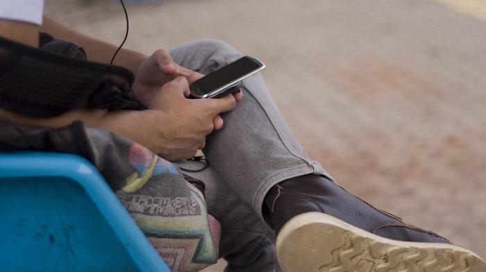 Ilustrasi seseorang memegang ponsel.