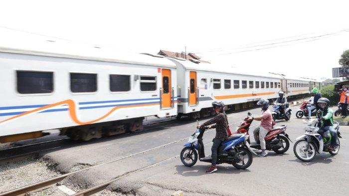 Potret pengendara sepeda motor yang berada di perlintasan kereta api
