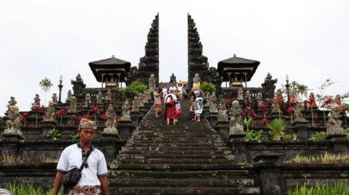 Umat Hindu usai sembahyang di Pura Besakih, Kecamatan Rendang, Karangasem, Bali. Pura terbesar di Bali yang mengalami perkembangan sejak masa pra-hindu, ini berorientasi ke Gunung Agung yang dianggap sebagai tempat tinggal para dewata.